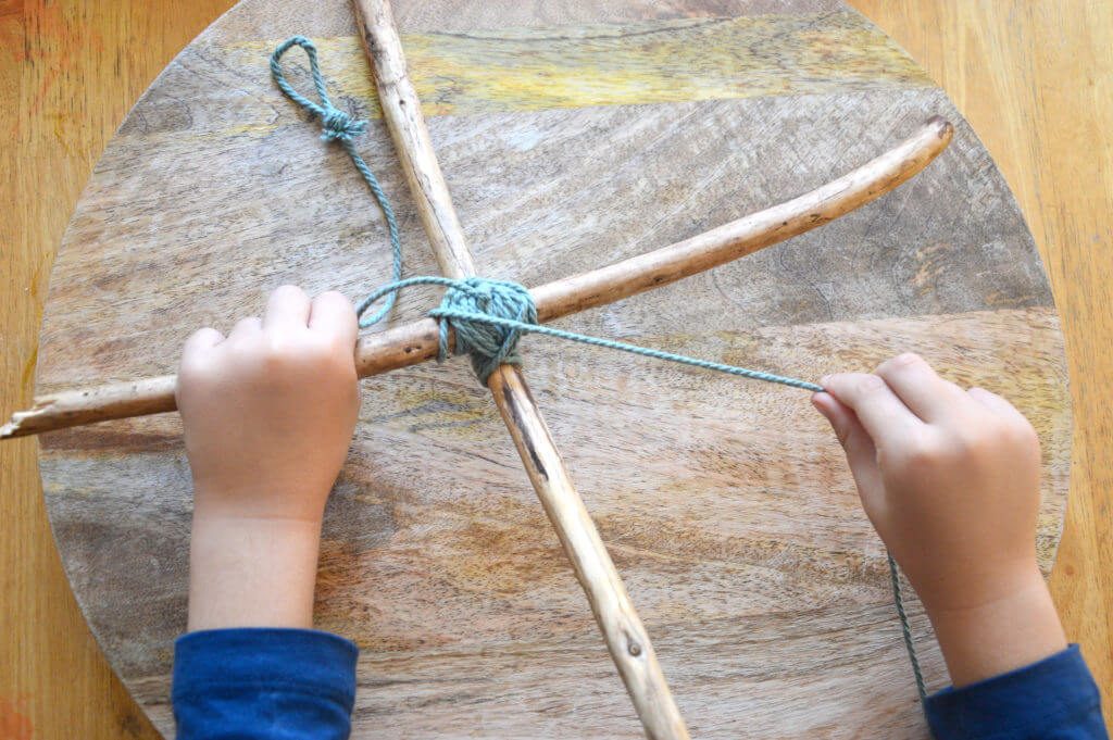 Child-winding-cord-around-sticks-in-x-shape-for-nature-mobile-1024x681.jpg#asset:13579